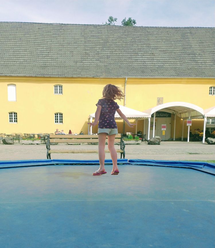Kind springt auf Trampolin im Schloss Beck